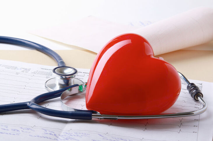 czerwone serce z tworzywa i słuchawki lekarskie leżące na dokumentach