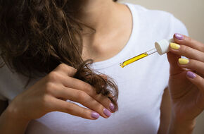 Kobieta pielęgnuje włosy olejem marula 