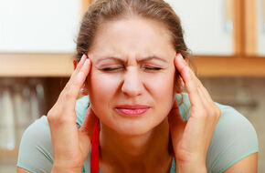 Kobieta odczuwa napięciowy ból głowy