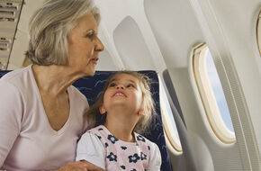 Babcia z wnuczką w samolocie wyglądają przez okno 