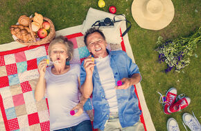 Para dojrzałych ludzi leżąca na piknikowym kocu
