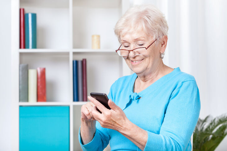 Seniorka korzystająca z telefonu komórkowego