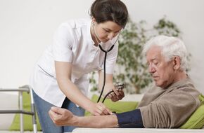 Pielęgniarka bada ciśnienie krwi starszemu mężczyźnie