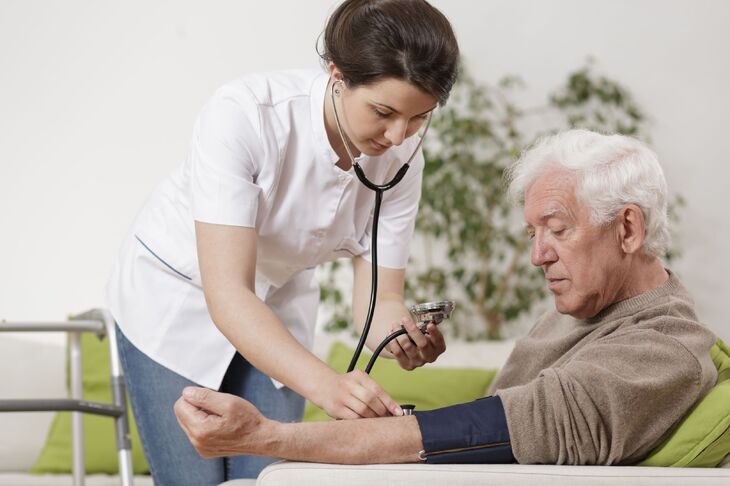 Pielęgniarka bada ciśnienie krwi starszemu mężczyźnie