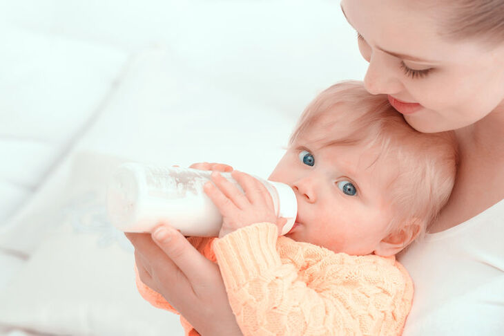 Dziecko pije mleko z butelki antykolkowej
