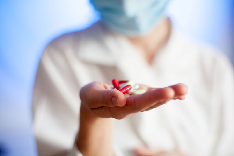 Lekarz trzymający tabletki na dłoni