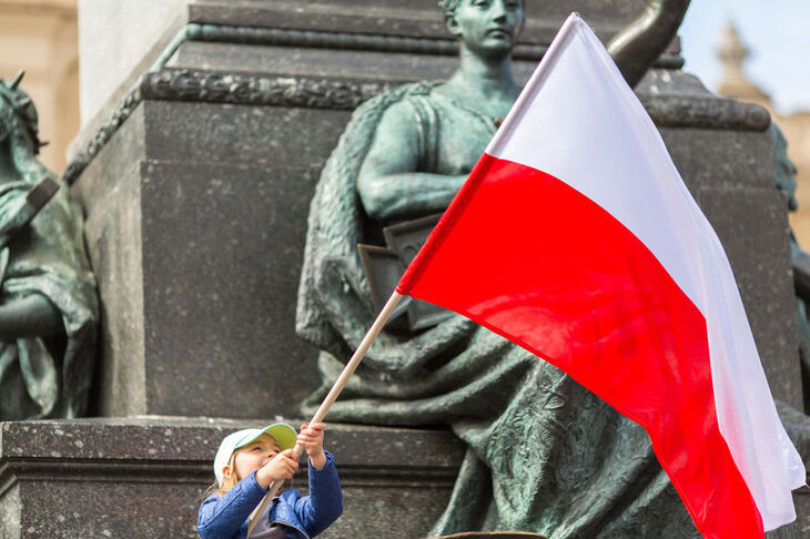 Dziecko trzyma w rękach flagę Polski