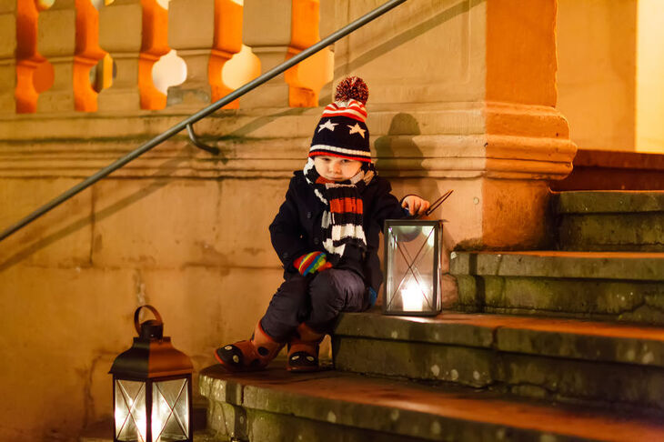 Chłopiec z lampionem na kościelnych schodach