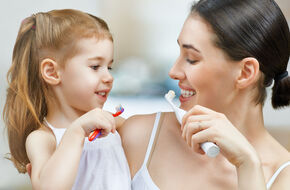 Kobieta z córką myją zęby 