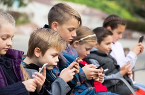 Dzieci trzymające w dłoniach telefony komórkowe