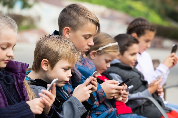 Dzieci trzymające w dłoniach telefony komórkowe