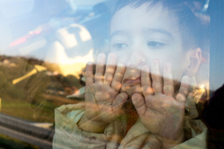 Chłopiec przykładający twarz do szyby samochodu