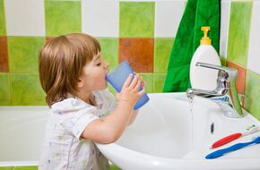Dziecko płucze jamę ustną po myciu zębów 