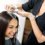 Fryzjer robi kobiecie refleksy na ciemnych włosach