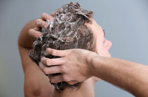 Mężczyzna myje włosy szamponem
