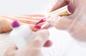 Kosmetyczka maluje paznokcie lakierem hybrydowym
