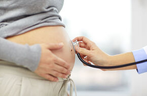 Lekarz osłuchuje brzuch kobiety w ciąży