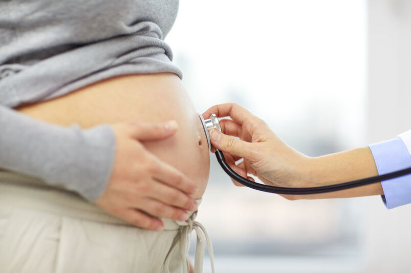 Lekarz osłuchuje brzuch kobiety w ciąży