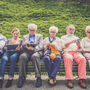 Grupa seniorów siedzi na ławce