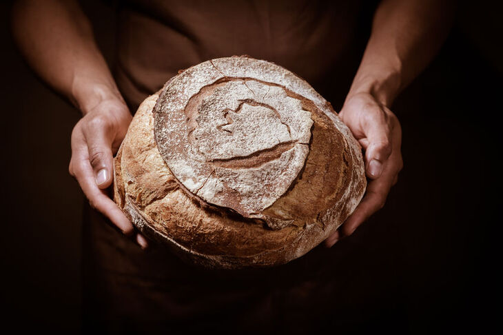 Kobieta trzyma w dłoniach chleb