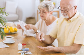 Seniorzy trzymający w dłoni leki