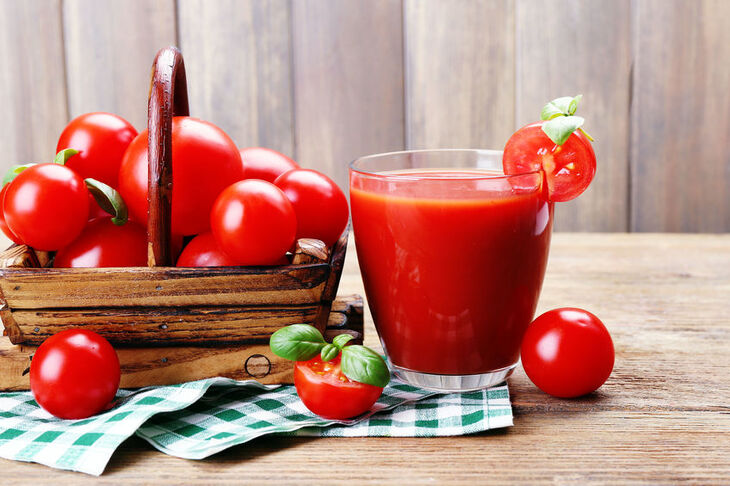 Szklanka soku pomidorowego i koszyk z pomidorami