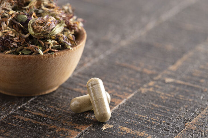 Ziołowe tabletki na menopauzę i miseczka z ziołami