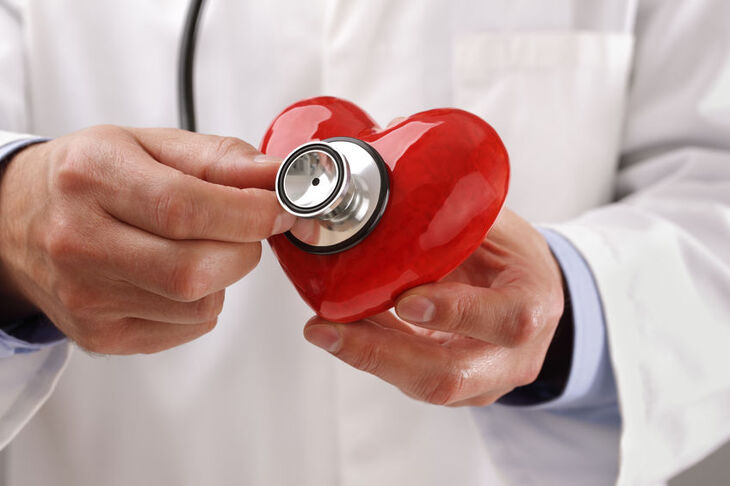 Lekarz trzyma stetoskop na modelu serca