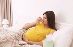 Chora kobieta w ciąży leży w łóżku