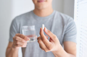 Młody mężczyzna zażywa antybiotyk