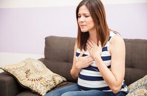 Kobieta odczuwa objawy nadkwasoty żołądka