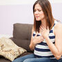 Kobieta odczuwa objawy nadkwasoty żołądka