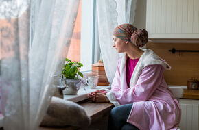 Kobieta z chorobą nowotworową wygląda przez okno