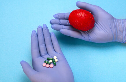 Model mózgu i tabletki w dłoniach