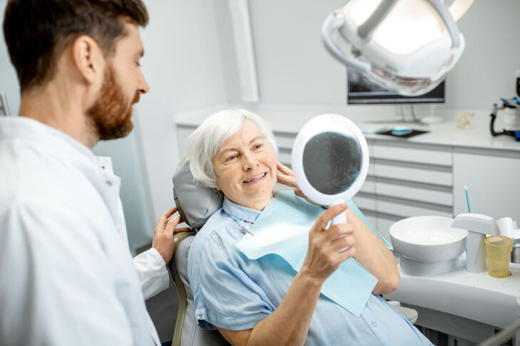 Kobieta ogląda protezę u stomatologa