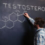 Mężczyzna pisze na tablica wzór chemiczny testosteronu 