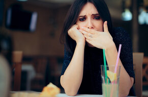 Kobieta cierpiąca z powodu odbijania po jedzeniu