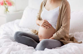 Kobieta w ciąży trzyma się za brzuch