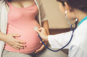 Lekarz bada kobietę w ciąży 