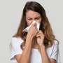 Kobieta wydmuchuje nos po zastosowaniu antybiotyku na zatoki