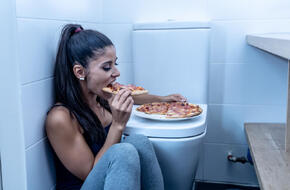 Kobieta chorująca na bulimię w toalecie