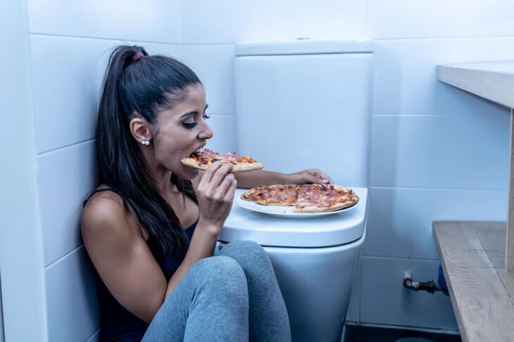 Kobieta chorująca na bulimię w toalecie