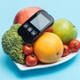 Owoce dla cukrzyka na talerzu i glukometr