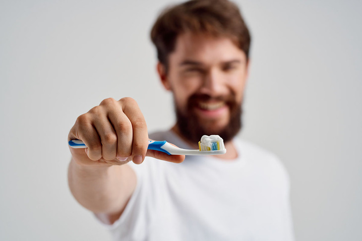 Mężczyzna pokazuje jakiej używa pasty do zębów
