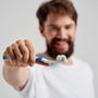 Mężczyzna pokazuje jakiej używa pasty do zębów