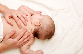 masażysta masuję plecy niemowlaka z obniżonym napięciem mięśniowym