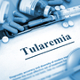Napis tularemia na tablecie w otoczeniu leków
