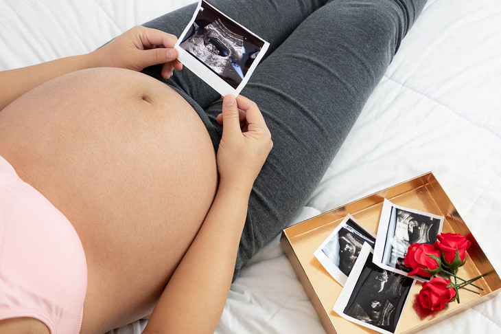 Kobieta w ciąży prezentująca swój brzuch