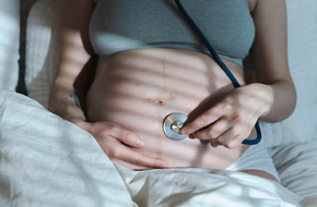Kobieta w ciąży sprawdzająca ruchu swojego dziecka