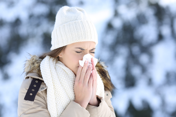 Kobieta wydmuchuje nos zimą i zastanawia się nad kwestią przeziębienie i grypa a odporność